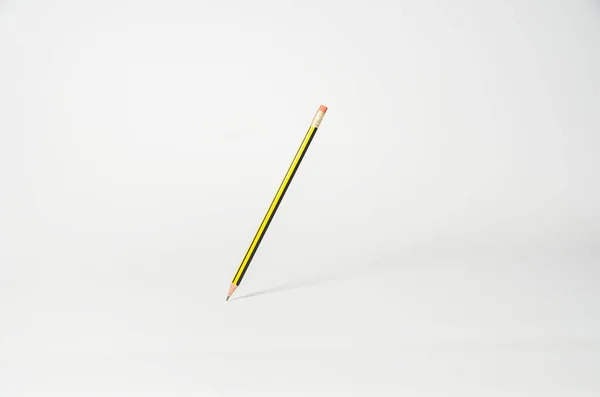 Ołówek wisi w powietrzu na jasnym tle — Zdjęcie stockowe