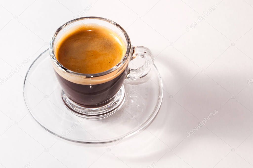 Coffee americano in a transparent cup and saucer on a white background