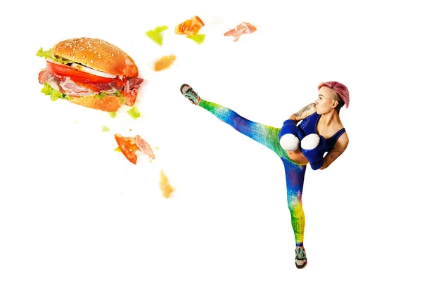 A young girl kick a hamburger. The concept is the fight against unhealthy food. — 스톡 사진