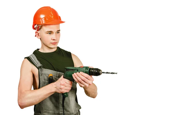 Jong werken guy in hard hoed houdt boor geïsoleerd op een witte achtergrond — Stockfoto