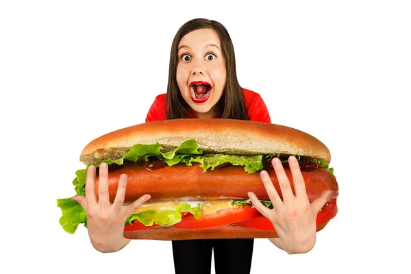 Young cute funny girl holds in front of herself huge hot dog, isolated on a white background — 스톡 사진