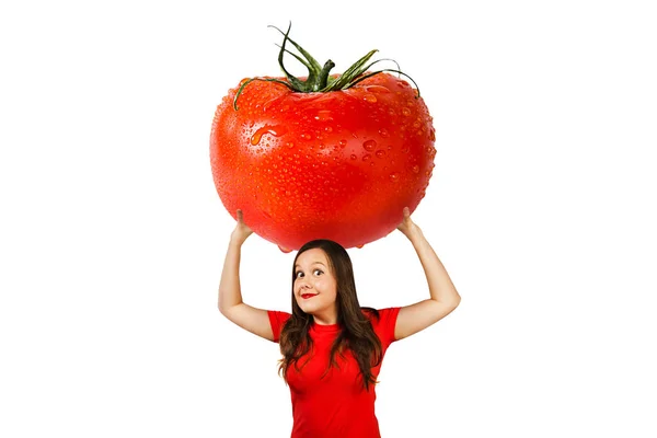 Bonito engraçado jovem menina segura sobre si mesma enorme tomate vermelho com gotas de água, isolado em um fundo branco — Fotografia de Stock