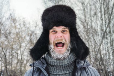 Sibirya 'lı sakallı bir Rus kışın dondurucu soğukta soğuktan donar ve kulaklı bir şapka takar..
