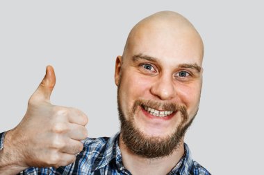 Sakallı, mutlu, kel adam izole bir arka planda baş parmak gösteriyor.