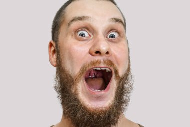 Kızıl sakallı, ağzı açık ve kocaman gözleri olan adam. Yakın plan portre