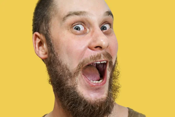 Very surprised scared funny face of a bearded guy with open mouth and big eyes on an isolated background — 스톡 사진