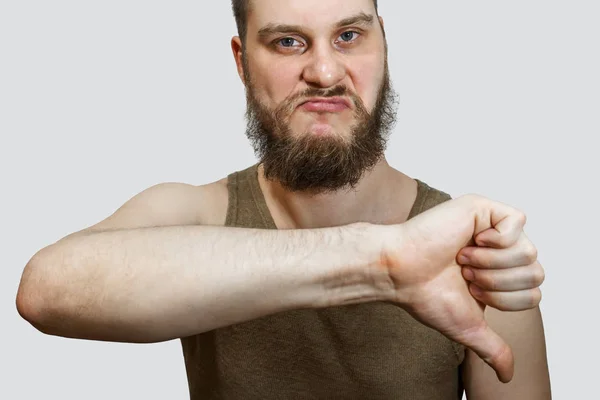 Homem com o polegar para baixo. tipo a expressar desaprovação. Não gosto do conceito. Hipster macho com barba mostrando polegar para baixo gesto — Fotografia de Stock