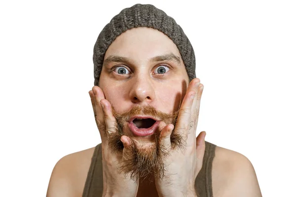 Portrét překvapeného vousatého chlapa v klobouku s otevřenými ústy, pročesává si vousy rukama a prsty ve studiu — Stock fotografie
