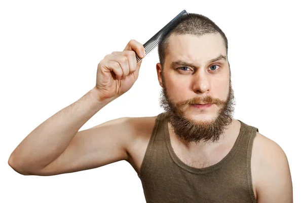 Cara barbudo penteando sua cabeça careca com uma escova de cabelo no estúdio em um fundo isolado branco — Fotografia de Stock