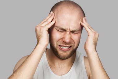 Genç adam hasta. Baş ağrısı, stres ya da grip. Acil tedavi konsepti.