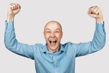 Mutlu kel adam ofis çalışanı kazandığına sevindi, gülümsedi, güldü ve elini kaldırdı.