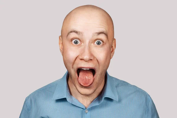 Plešatý dospělý chlap otevřel ústa a ukazuje jazyk na recepci lékaře — Stock fotografie