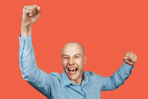 happy bald guy office worker glad to win, smiles, laughs and raised his hands on an isolated background
