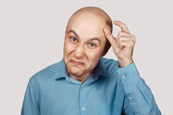 A bald guy shows a hand gesture meaning a very small amount of something Royalty Free Stock Photos