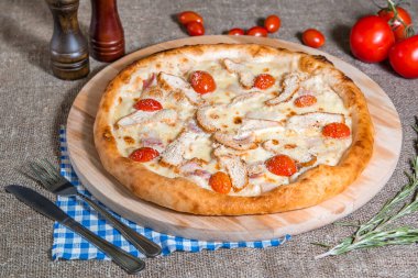 Peynirli, domatesli, pastırmalı, arka planda jambonlu pizza.