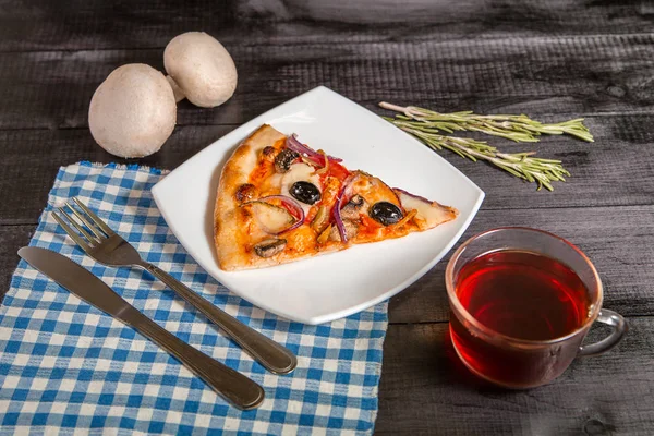 Rebanada de pizza en un plato blanco sobre fondo natural — Foto de Stock