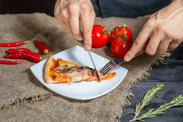 Man 's hands cut a slice of pizza — стоковое фото