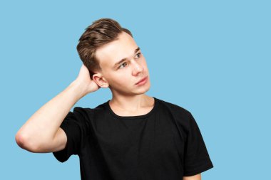 Düşünceli yakışıklı genç adam ayakta duruyor ve düşünüyor, izole.