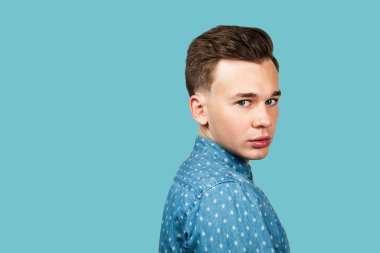 Siyah tişört giymiş, kameraya bakan genç adam portresi.