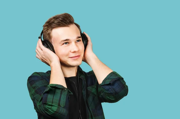 Λευκός νεαρός ακούει μουσική στα ακουστικά. πορτρέτο ενός καυκάσιου όμορφου άντρα — Φωτογραφία Αρχείου