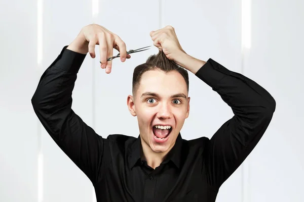 Ein weißer junger Mann schneidet sich mit der Schere die Haare. — Stockfoto