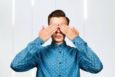 Yüzünü mavi gömlekle örten adam.