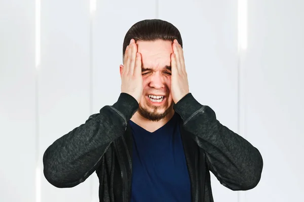 Upset unhappy young man squeezing head with hands, suffering from headache. People, stress, tension and migraine — Stock Photo, Image