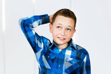 Düşünen çocuğun portresi. Elleri havada, yukarı bakıyor. beyaz arkaplan