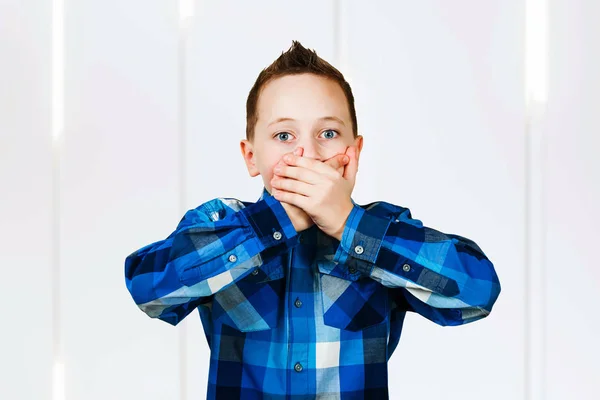 Retrato de menino cobrir boca com as mãos, sobre fundo branco . — Fotografia de Stock
