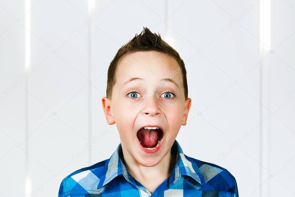 SURPRISED LITTLE BOY WONDERIN and scream with open mouth on white background