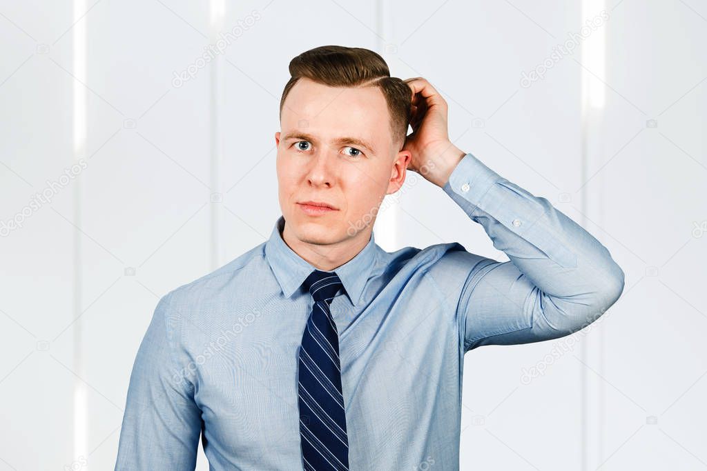 Young pensive guy businessman think, dressed in blue shirt and tie