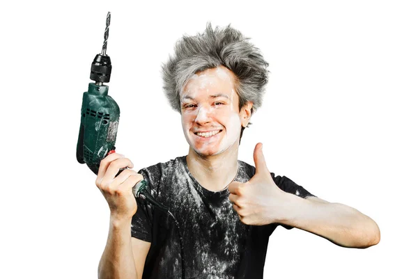 Dirty young builder guy in plaster is hold a green drill perforator on isolated background at home during repairs — Stock Photo, Image
