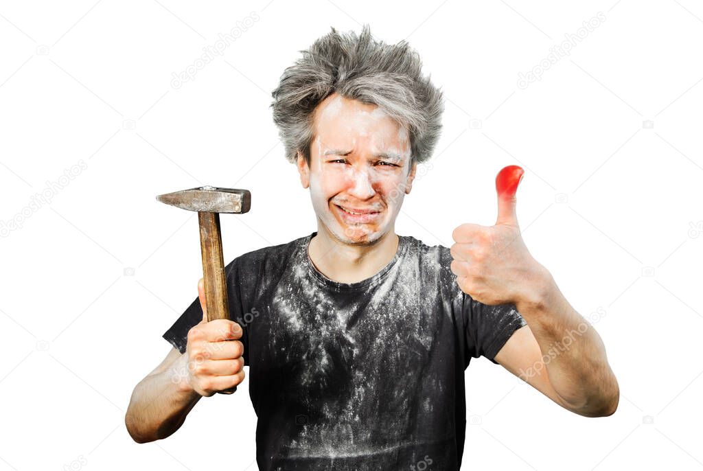 Dirty young builder guy fail is hold a hammer, hit the finger on a white isolated background at home during repairs