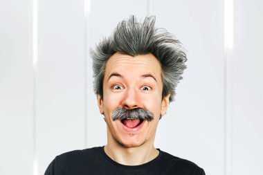 Neşeli, yaşlı bir adamın portresi. Gri, uzun saçlı, ağzı açık, Einstein tarzında gülümseyen.