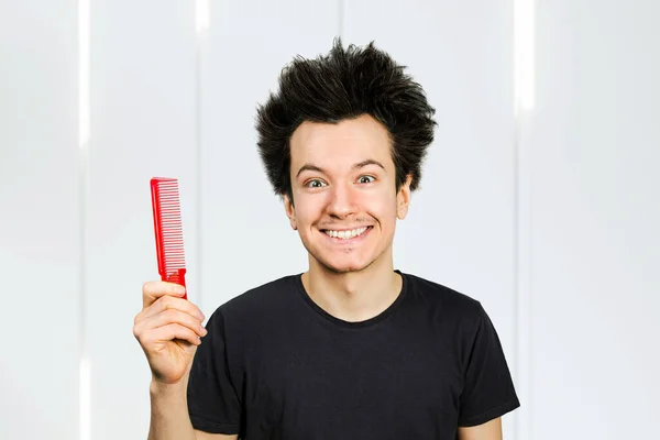 long hair guy hold comb on a white background.