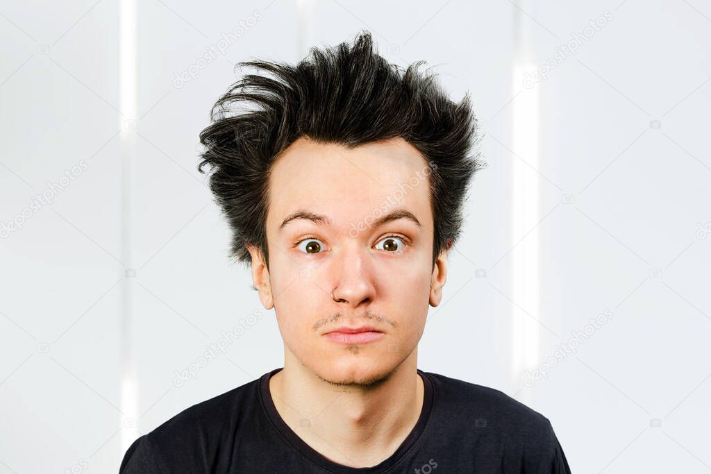 shaggy guy with long hair looks in camera, on white background