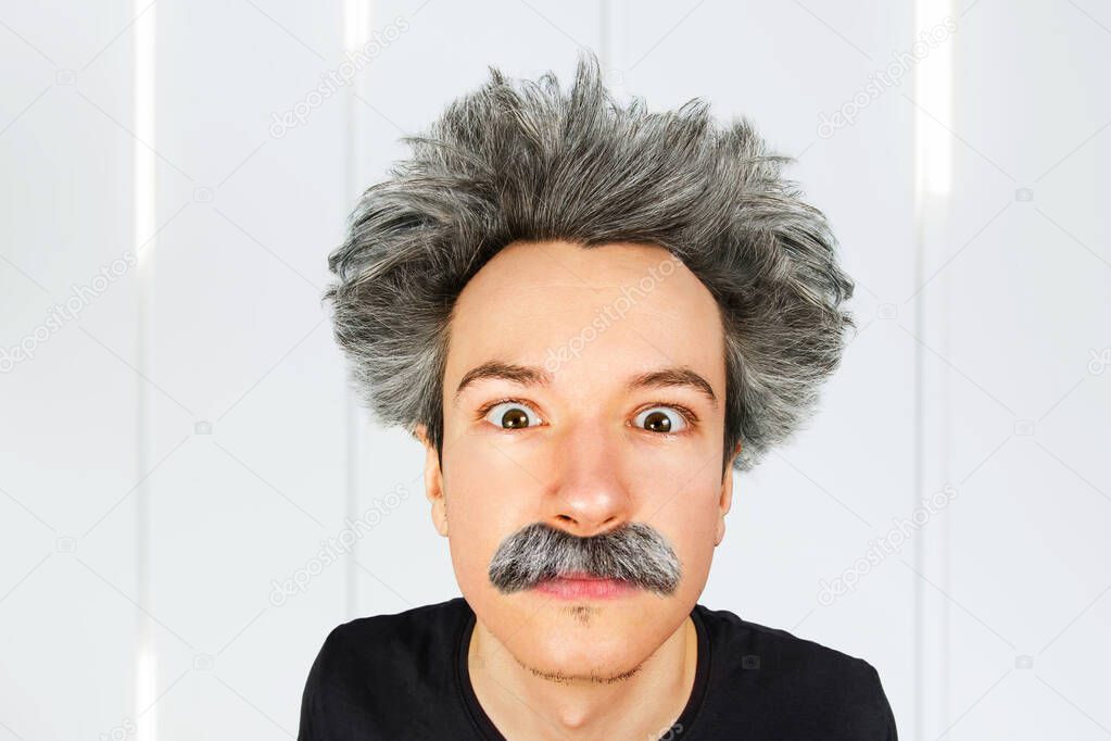 Portrait of jocular aging guy with grey long hair sticking his tongue out in Einstein manner