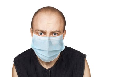 Tıbbi maskeli, şaşkın bakışlı hasta bir genç adam. Grip salgını sırasında virüs koruması. corona virüsü.