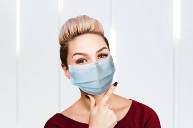 Koruyucu yüz maskesi takan genç kadın virüs enfeksiyonunu ve kirliliği önlüyor.