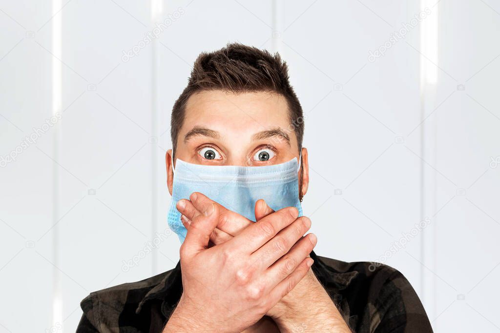 Sick young man with a surprised look in a medical mask. Virus protection during an influenza epidemic. corona virus disease 2019