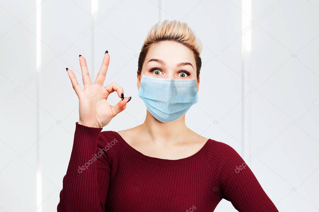 young woman sign ok, wearing protective face mask prevent virus infection, pollution.