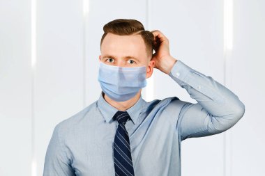 İş adamı, mavi gömlekli ve kravatlı adamın koruyucu maske takarak virüs enfeksiyonunu önlediğini düşünüyor..