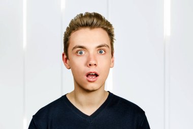 Pompadour saç stili ile şaşırmış genç bir adamın portresi..