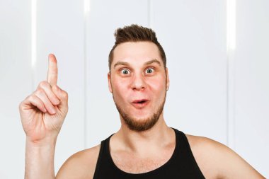 Kafasında siyah tişört olan sakallı genç adam parmağını kaldırıyor..