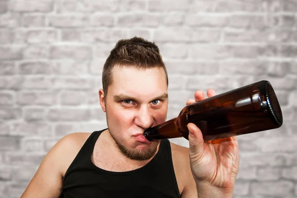 Młody Człowiek Alkoholik Bólem Głowy Trzymający Butelkę Piwa — Zdjęcie stockowe