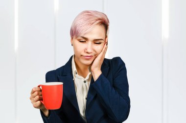 Genç uykucu ofis çalışanı elinde bir fincan kahve tutuyor..