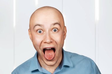 Portre kel adam ağzını açtı ve doktor resepsiyonunda dilini gösterdi..