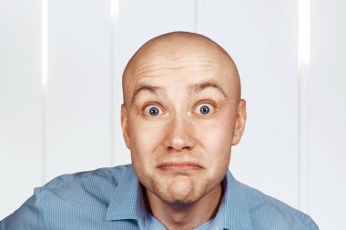 Portre kel, kendinden emin olmayan adam hiçbir şey anlamıyor. Şaşkınlık içindeki mavi gömlekli adam..