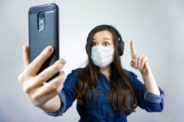 Tıbbi maskeli bir kadın, Corona virüsünde kendini tecrit ve karantina sırasında evden telefon görüşmesi yapıyor..