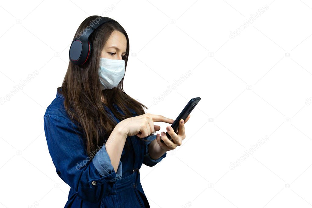 portrait woman wearing protective mask and headphones watching mobile phone online news about corona virus, covid-19.